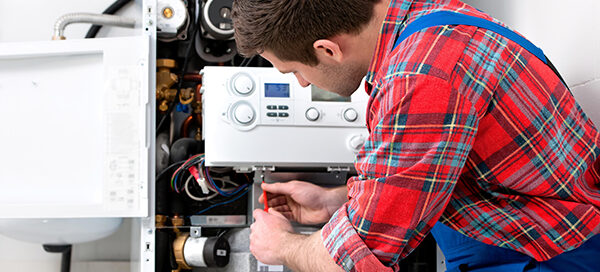 Monteur bei der Arbeit an einer Heizung.